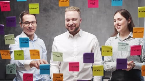 Team of Business People is Doing Brainstorm at a Meeting Using Stickers on the Glass Office Workers