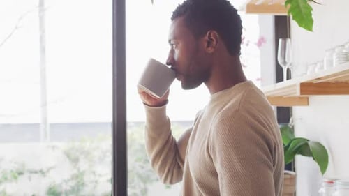 Man Enjoying Hot Drink in Modern Kitchen