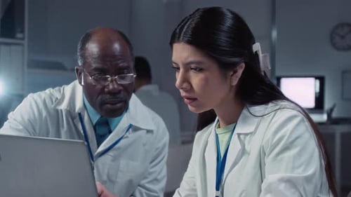 Estudante feminina diversificada e professor masculino trabalhando em pesquisas em laboratório