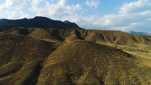 Vast Mountain Range Under Blue Sky with White Clouds