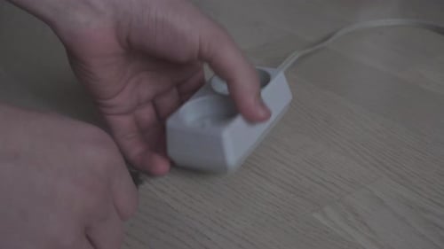 Mãos conectando/desconectando o antigo painel de alimentação europeu.