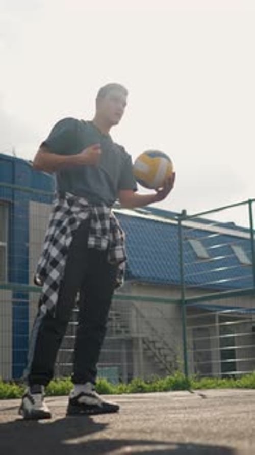 Athlete Bouncing and Slamming Volleyball During Training Session in Outdoor Arena