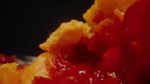 Dolly slider Close-up of a Split Bitter Melon, Highlighting the Juicy Red Seeds and Textured Yellow