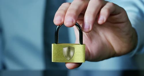 Hand Holding a Gold Padlock with Shield