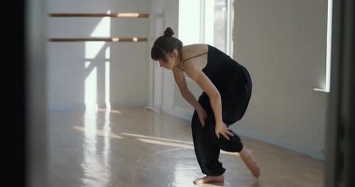Side View of Athletic Girl in Black Suit Performing Stretching and Dance Preparation Moves During