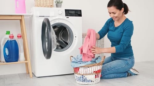 Woman Doing Laundry at Home With Modern Machine