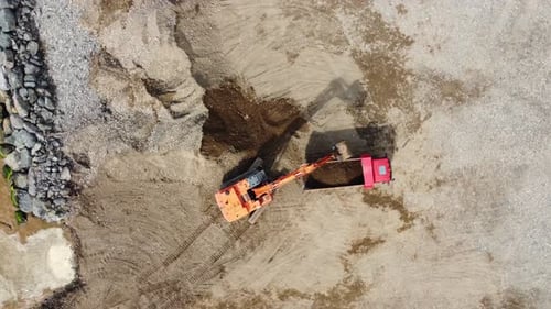 Excavator Loading Dirt Into Truck Aerial View