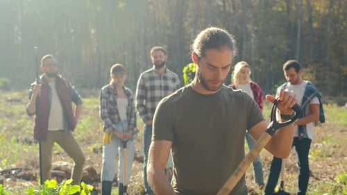 Group of Volunteers with Shovels in Wooded Area