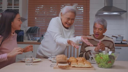 Family Laughing Together at Home Over Salad