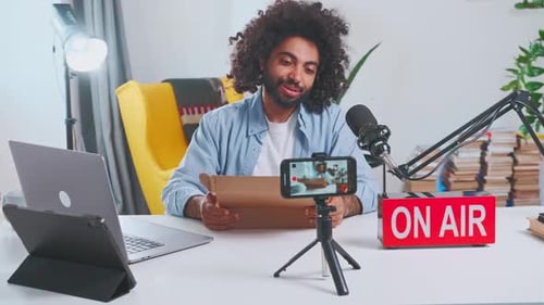 Young Adult Unboxing Product and Vlogging at Desk