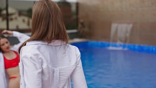 Women Relaxing by Rooftop Pool in City
