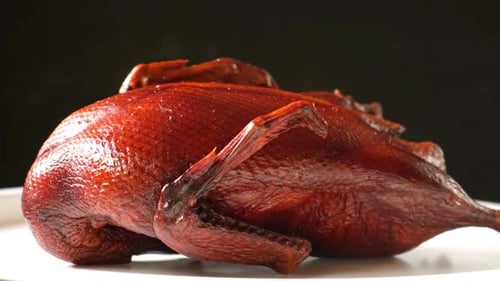 Whole Smoked Duck Platter Duck Carcass on a Cutting White Plate Rotating on a Turntable Grilled Wild