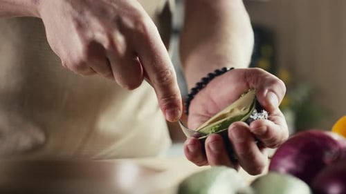 Scooping Avocado with a Spoon in Kitchen
