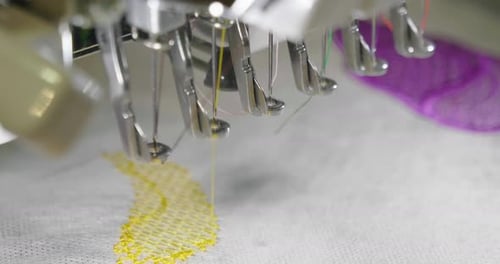 Una máquina de coser automática cose con hilos de colores y precisión a la hora de confeccionar cualquier forma o diseño.