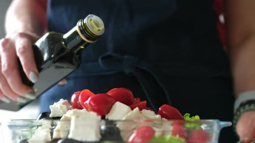 Preparing Healthy Salad with Tomatoes, Olives, and Feta