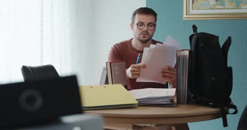 Man Reviewing and Correcting Documents at Home Office