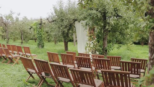 A Charming Outdoor Wedding Setup Beautifully Arranged in a Picturesque Orchard Setting