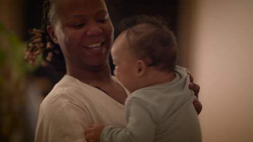 Loving Mother Holds Happy Infant Close