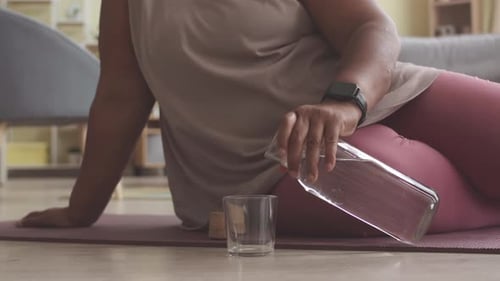 Woman Pours Water After Workout at Home