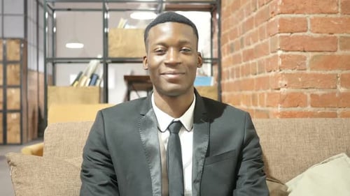 Confident Man in Suit Sitting on a Couch