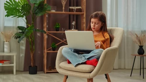 Junges Mädchen, das die Abendzeit zu Hause verbringt, Mädchen sitzt auf einem Stuhl im Wohnzimmer und arbeitet an