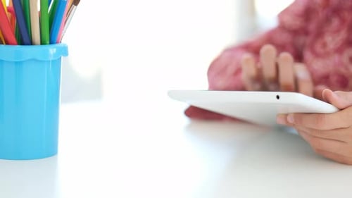 Child Using Tablet Computer at Desk