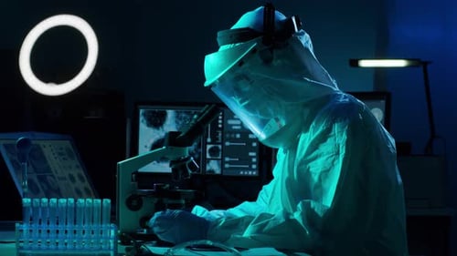 Researcher Analyzing Samples with Microscope in Laboratory