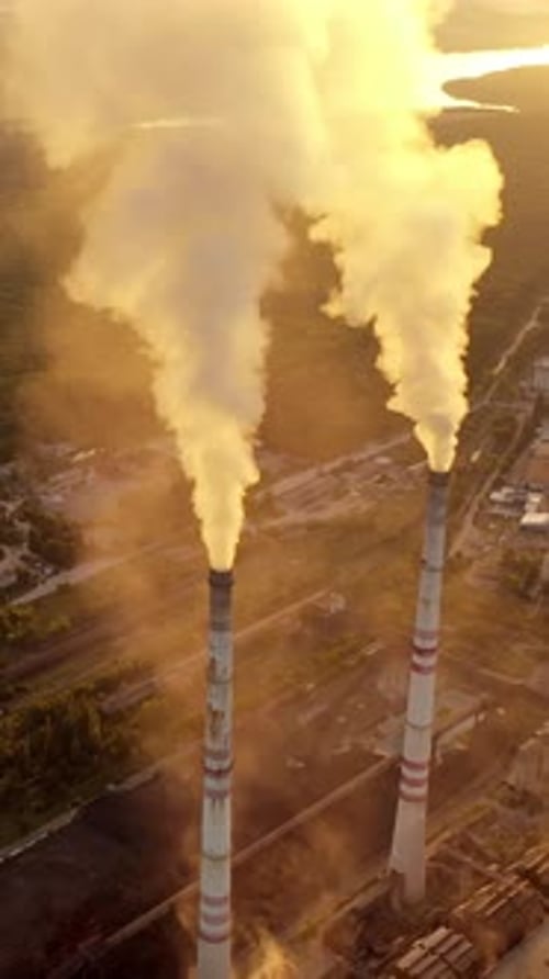 Industrial Smokestacks Billowing Smoke at Sunrise
