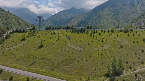 Summer Gondola Ride Over Lush Green Mountain Valley with Pine Trees