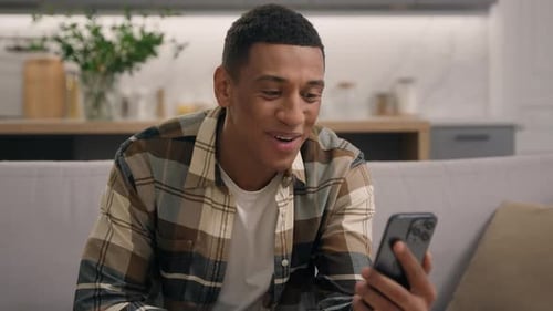 Young Adult Video Chatting On His Smartphone At Home