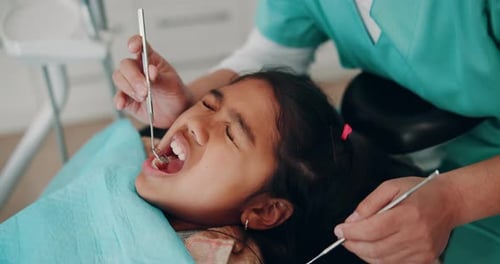 Dentist Examining Child's Teeth in Clinic