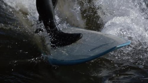Closeup of Foot on Surfboard Riding Wave