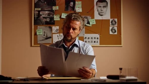 Detective's Office Middleaged Investigator in Shirt and Tie Sitting at Desk Examining Composite