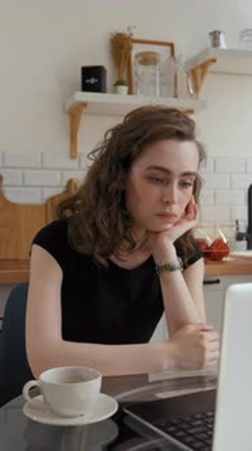 Vertical of Woman Listens to Online Courses Looking in Laptop at Table
