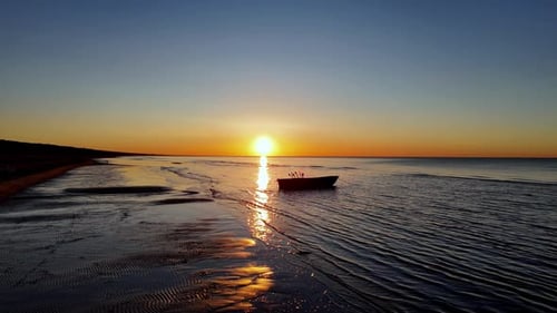 Ein ungewöhnlich schöner Sonnenuntergang im Meer zeigt die Schönheit des sandigen Strandgeländes und in der