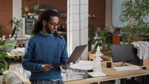 Biracial Male Engineer Posing with Laptop in Modern Office