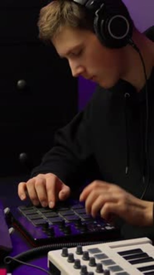 Young Man Composing Music with a Beat Machine