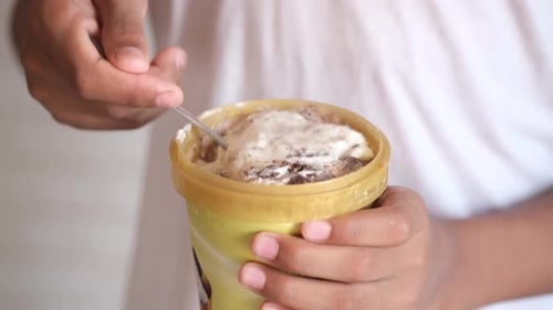 Young Men Eating Vanila Flavor Ice Cream in a Container