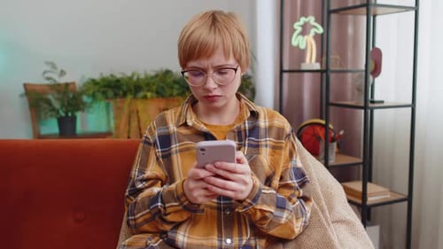 Stressed Woman Looking at Phone at Home