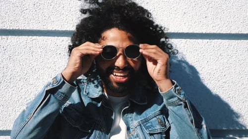 Man Puts on Sunglasses in the Sunshine