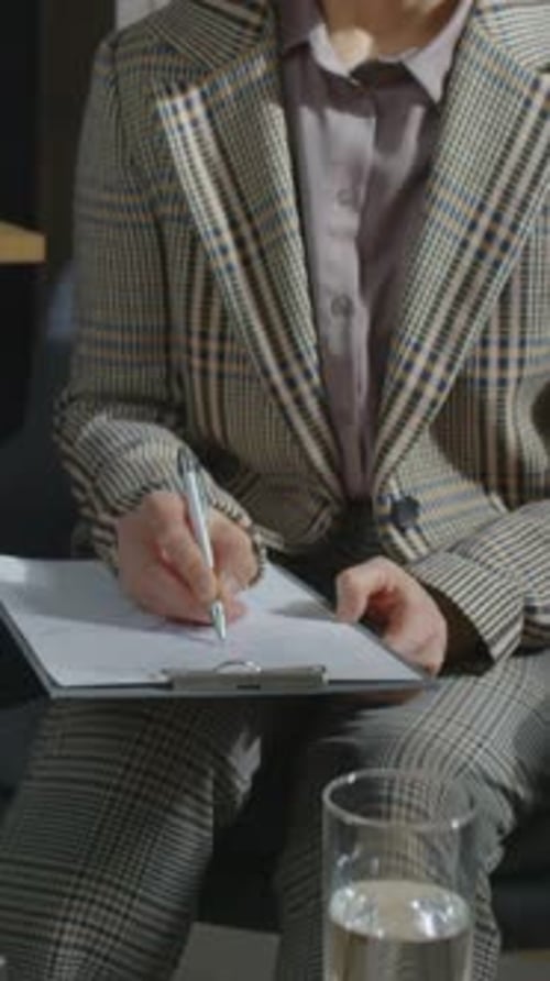 Woman Writing on Clipboard in an Office Setting