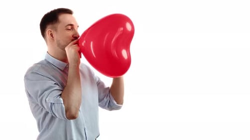 Man Inflating a Red Heart Balloon on White