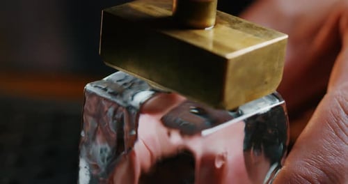 Golden Block Pressing into an Ice Cube