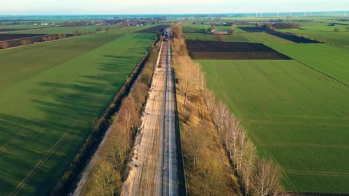 Aerial View of Rural Road Through Green Fields