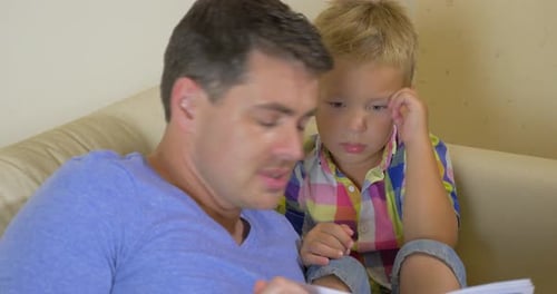 Father and Son Read Together at Home