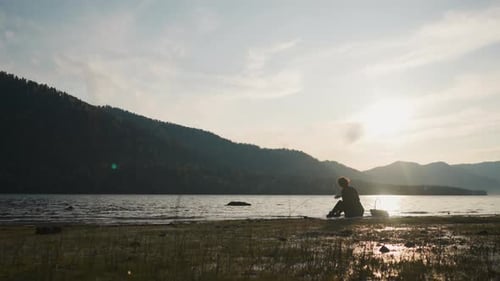 La señora disfruta arrojando piedras al río