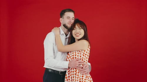 Loving Couple Embracing and Kissing on Red Background