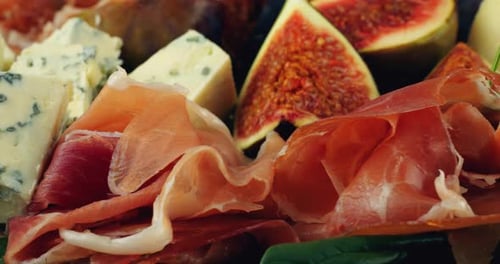 Figues, jamon, feuilles d'épinards et fromages bleus sur une planche de bois. Set de snacks.