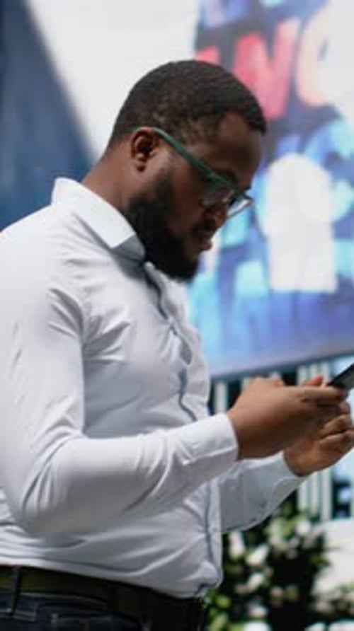 Vertical Video African American Male Follows Gps Directions on Phone As He Walks