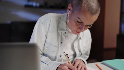 Woman Working at Home Writing in Notebook
